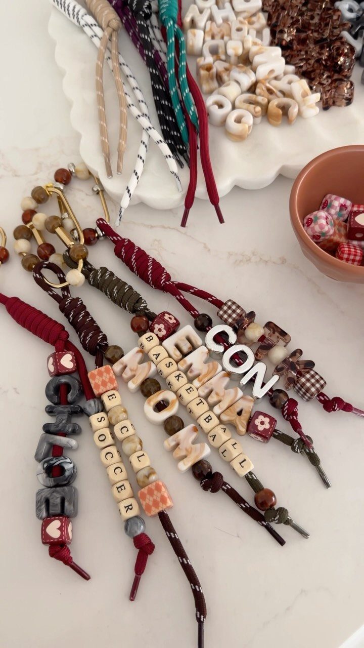 Handmade beaded keychains with personalized names and sports themes on a white surface.