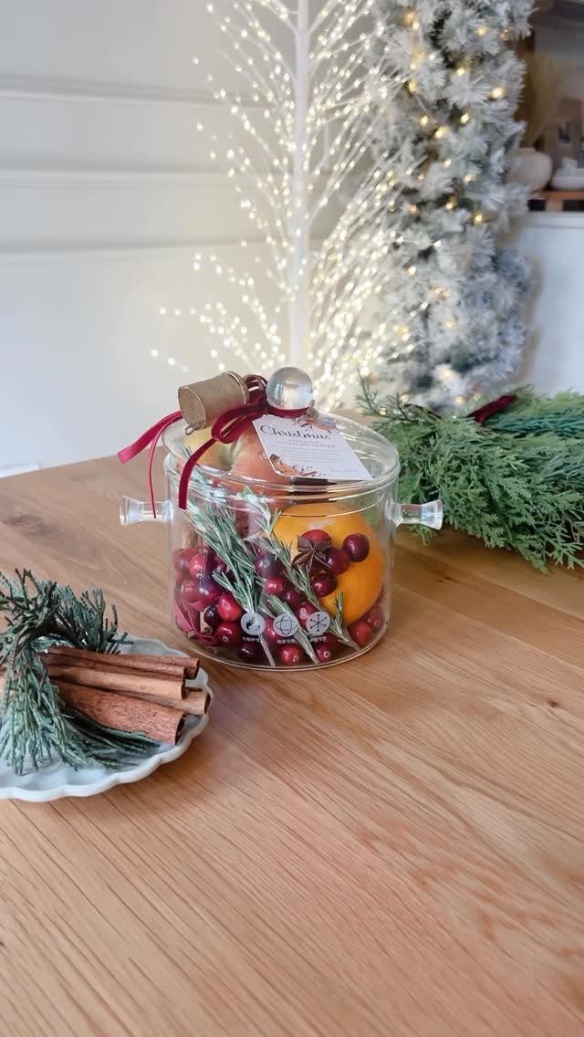 Glass jar filled with dried citrus and berries for DIY potpourri on wooden table