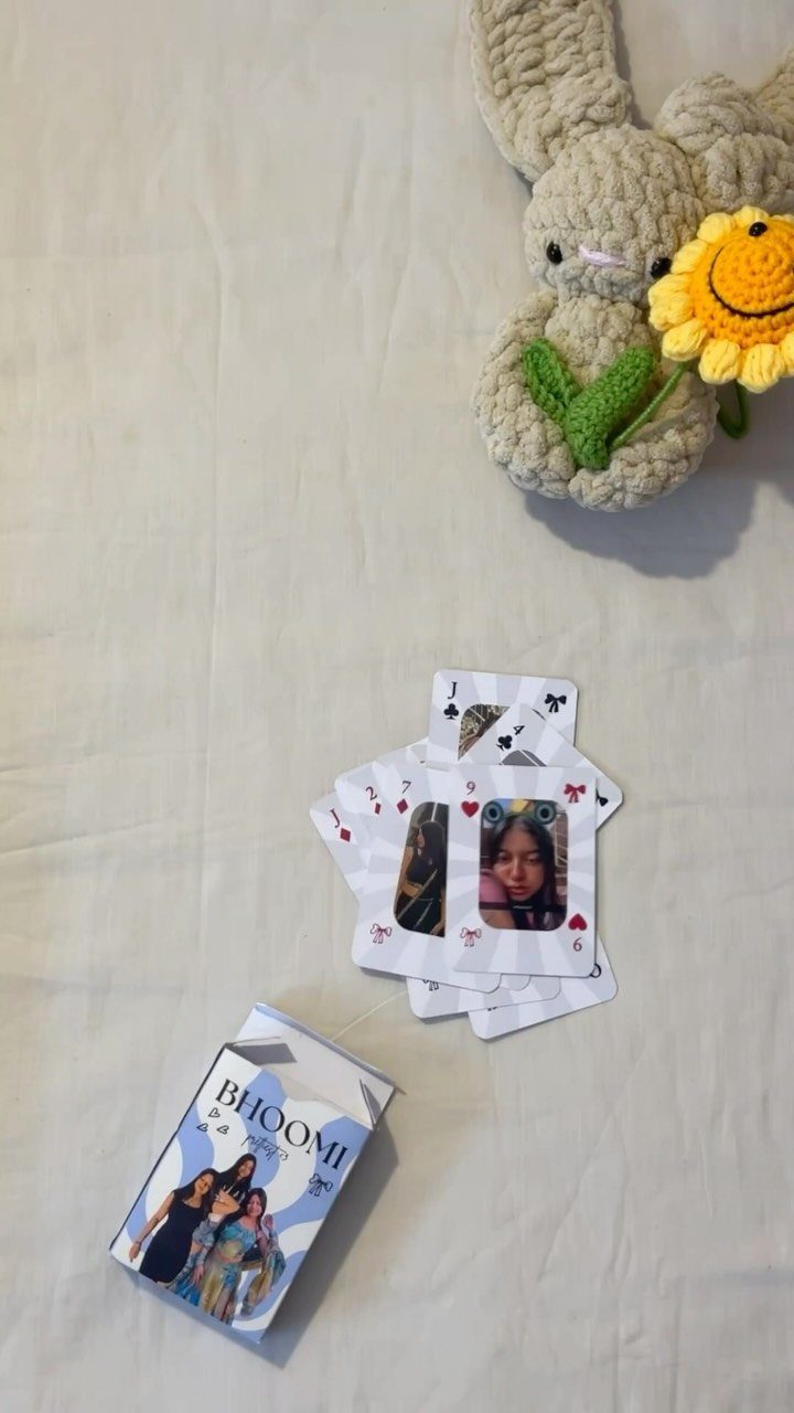 Customized playing cards and a photo box featuring personal photographs on white fabric.