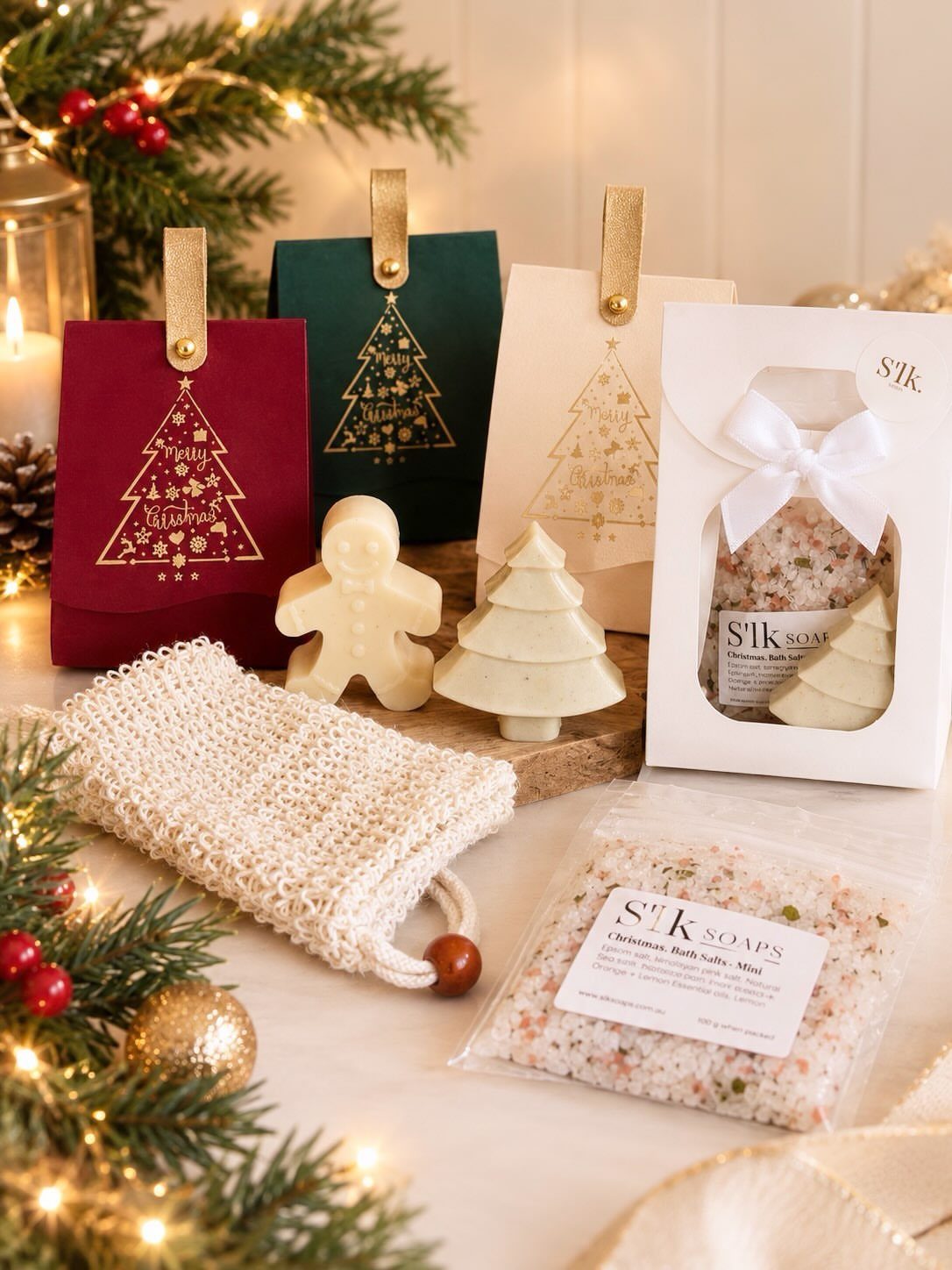 Pink bath salts in a clear bag with festive soaps and a sponge.