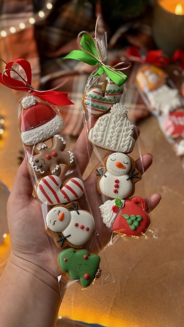 Decorated Christmas sugar cookies in clear plastic bags tied with festive ribbons.