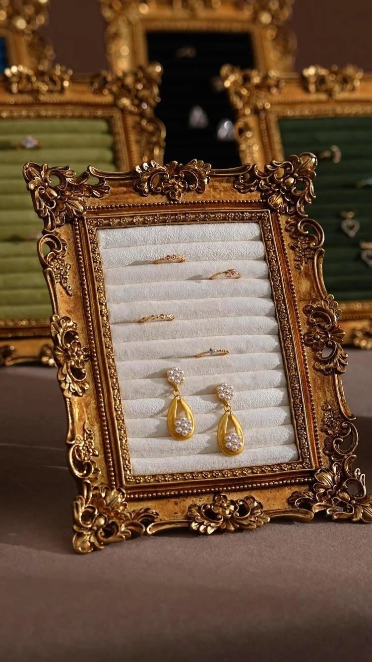 Ornate gold picture frame repurposed as a jewelry organizer holding rings and earrings.