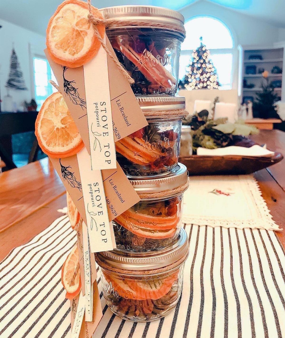 Stacked mason jars of stovetop potpourri with dried oranges and cinnamon sticks.