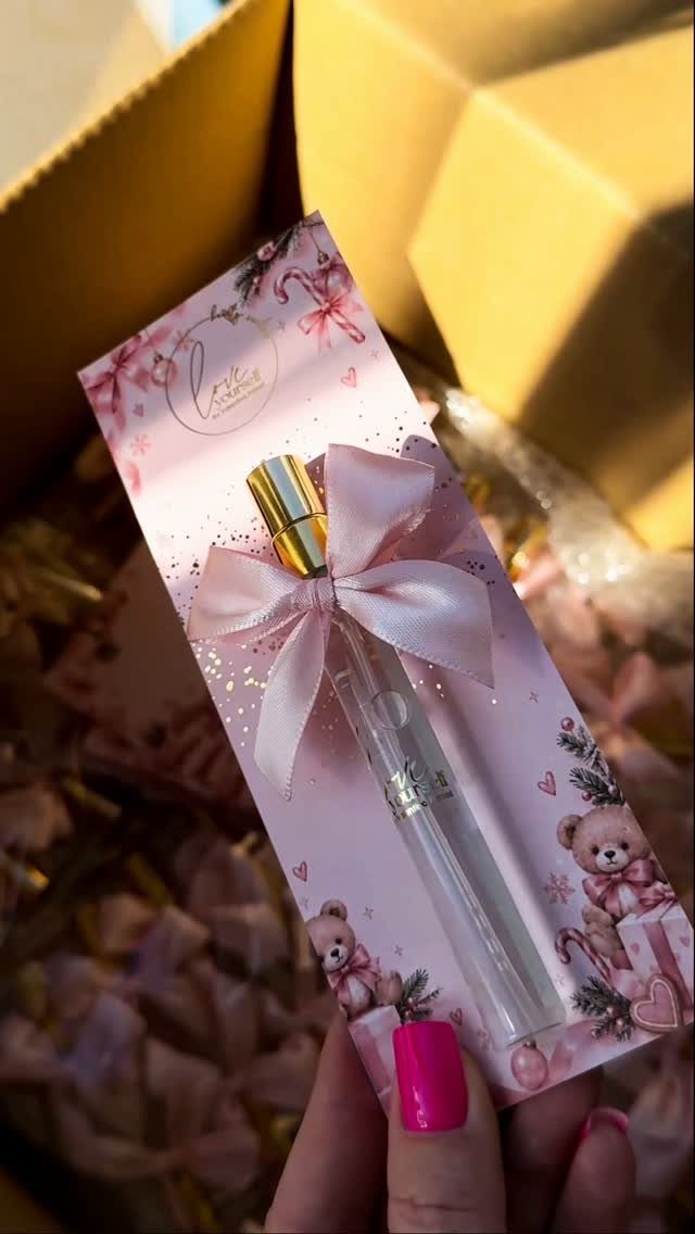 Small clear spray bottle with pink bow on a decorative teddy bear card.