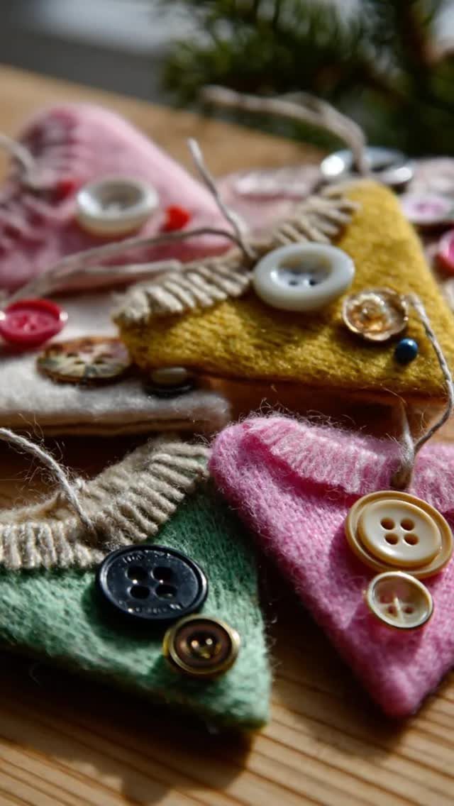 Triangular knitted sweater ornaments in various colors decorated with buttons on wooden surface