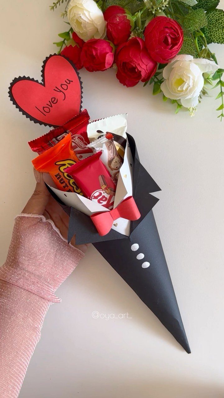 Candy bouquet wrapped in a black tuxedo design with a red heart topper.