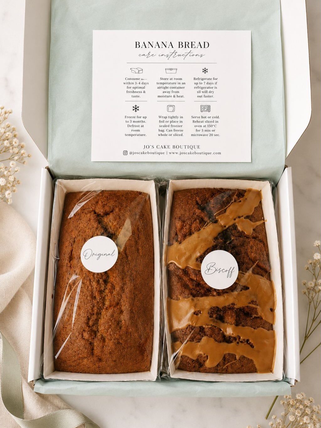 Two loaves of banana bread in a gift box with a care card.