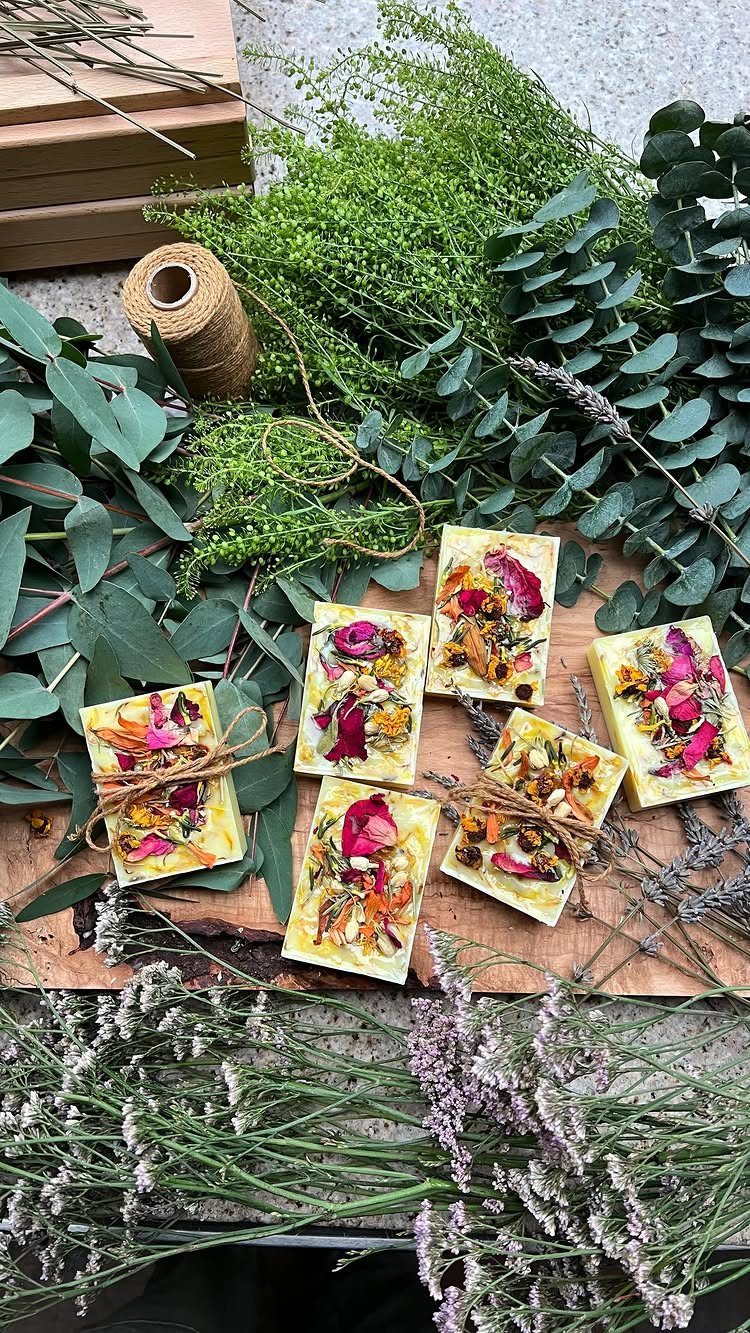 Handmade floral soap bars tied with twine on wood with eucalyptus and lavender.