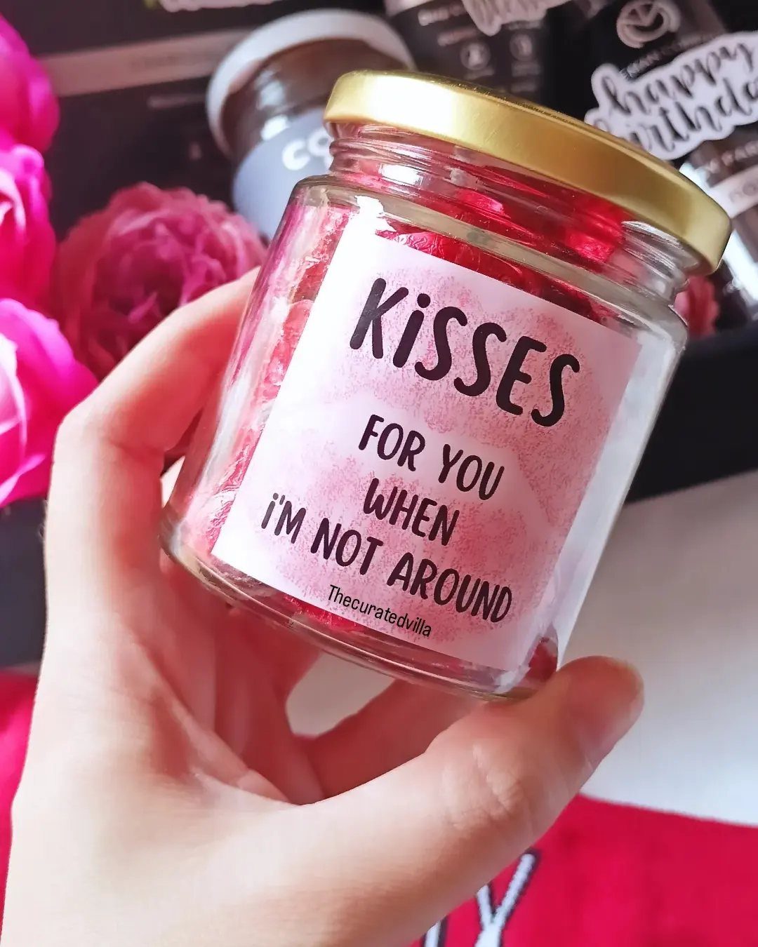 Glass jar filled with red heart candies and a romantic kisses label.