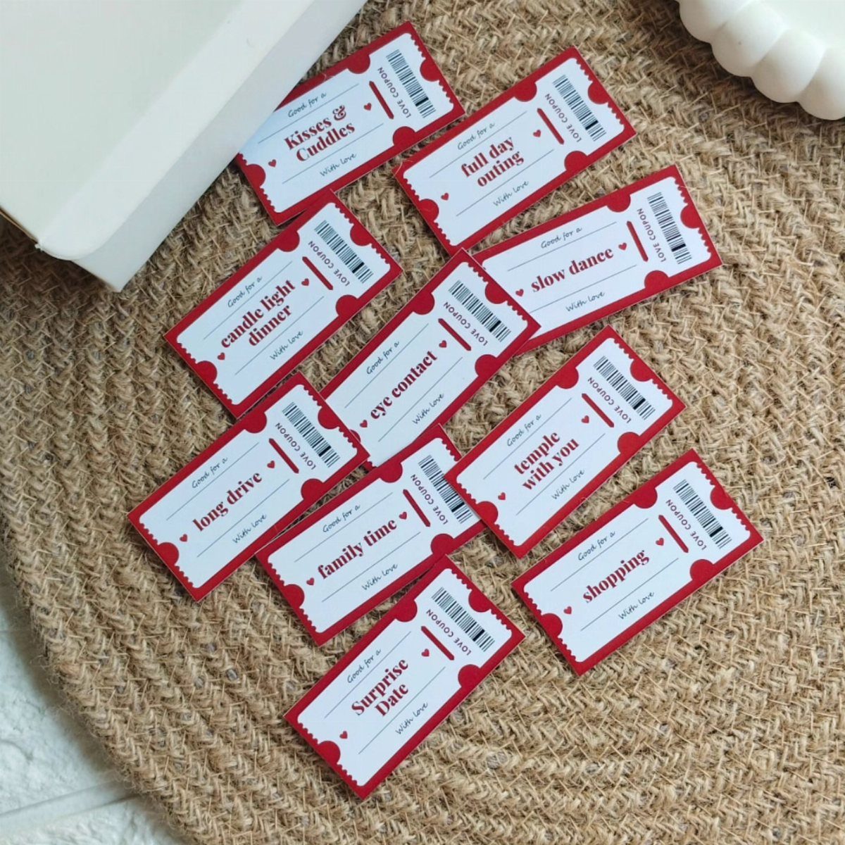 Red and white love coupons scattered on a woven straw mat.