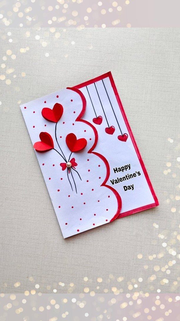 Handmade Valentine's Day card with 3D red hearts and polka dot patterns.