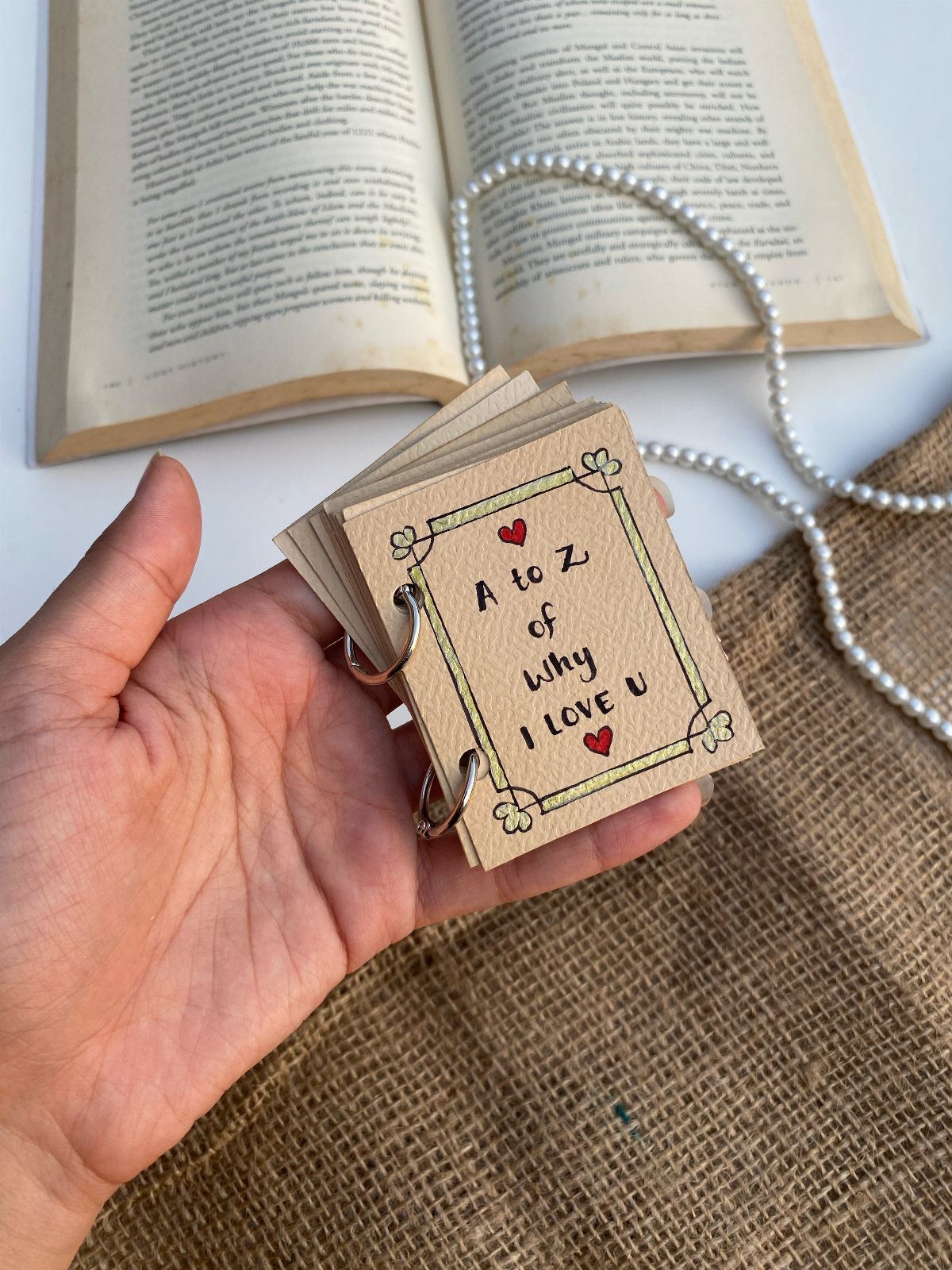 Handmade ring-bound love booklet with kraft paper cover and red heart decorations.