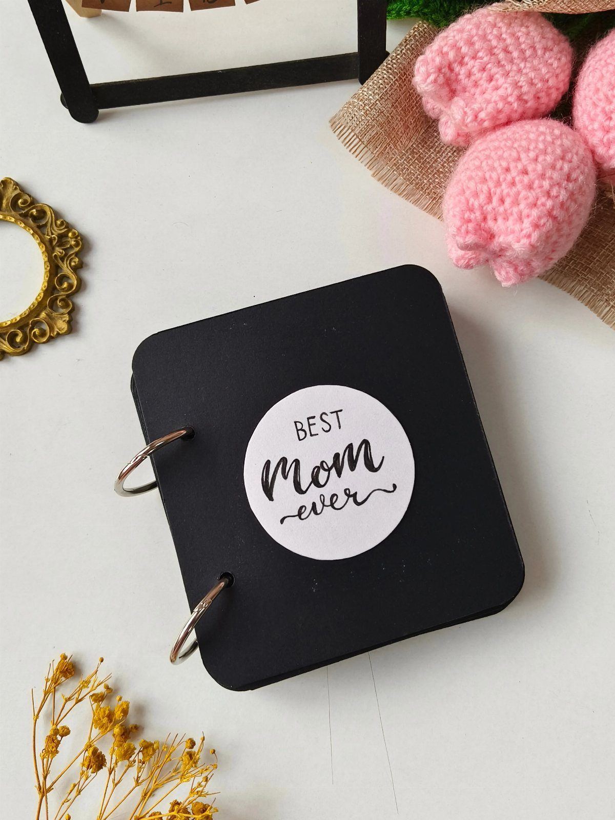 Black ring-bound love book with a Best Mom ever sticker and pink flowers.