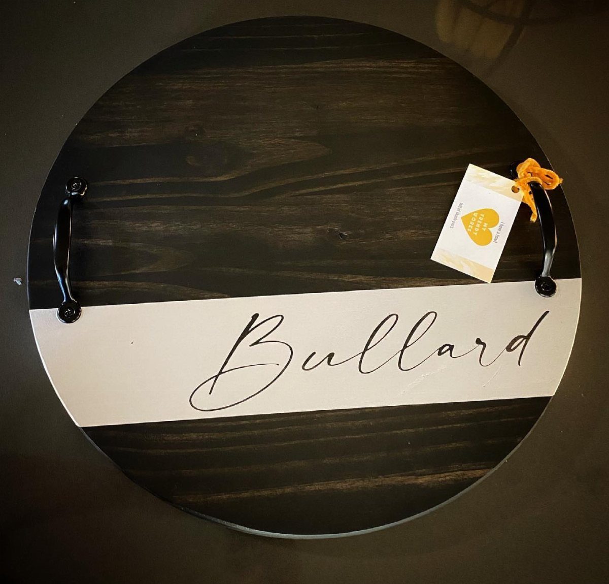 Round dark wooden tray with personalized Bullard name script and gift tag.