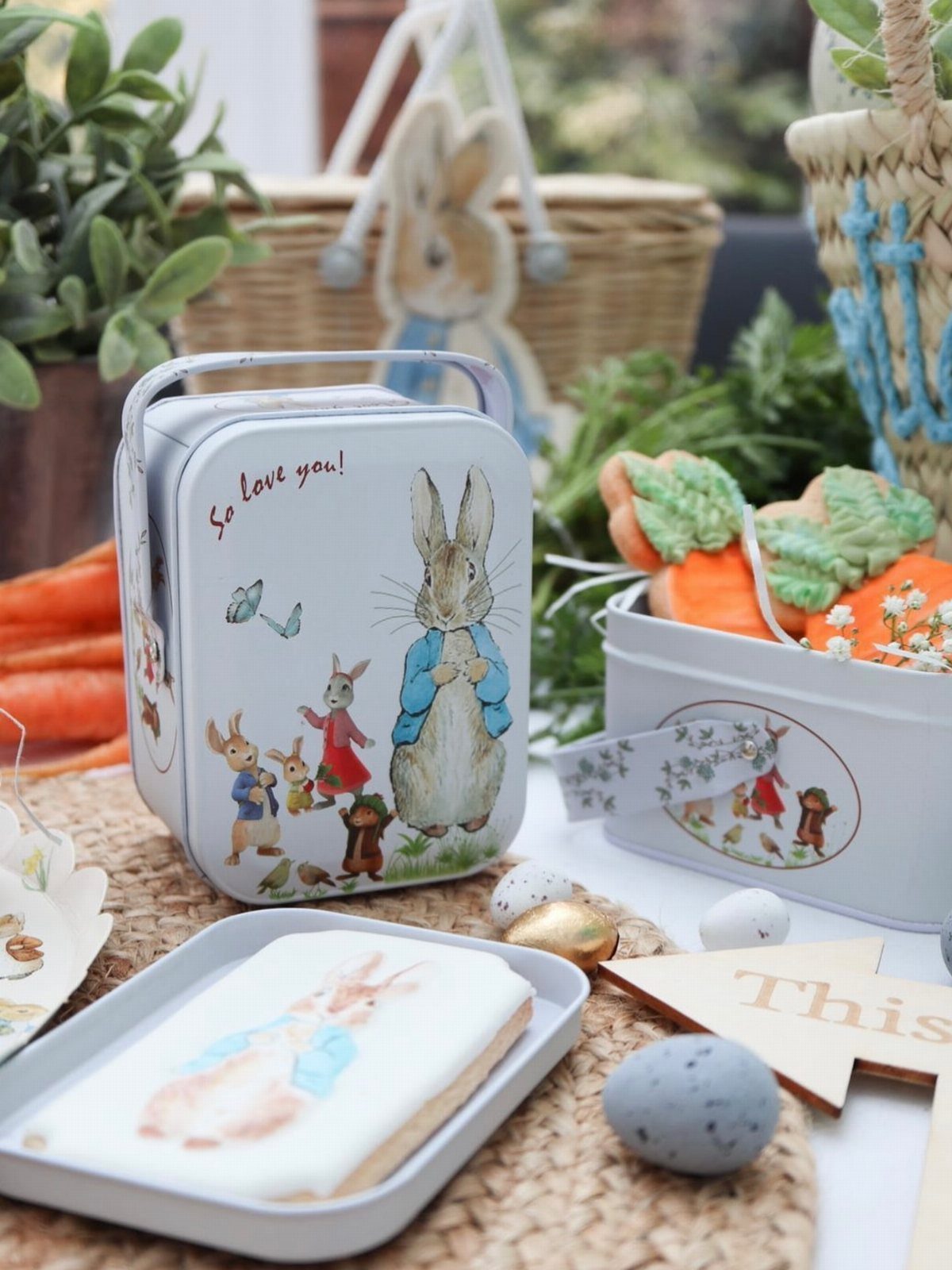 Peter Rabbit themed Easter treats with carrot cookies and a decorative metal tin.