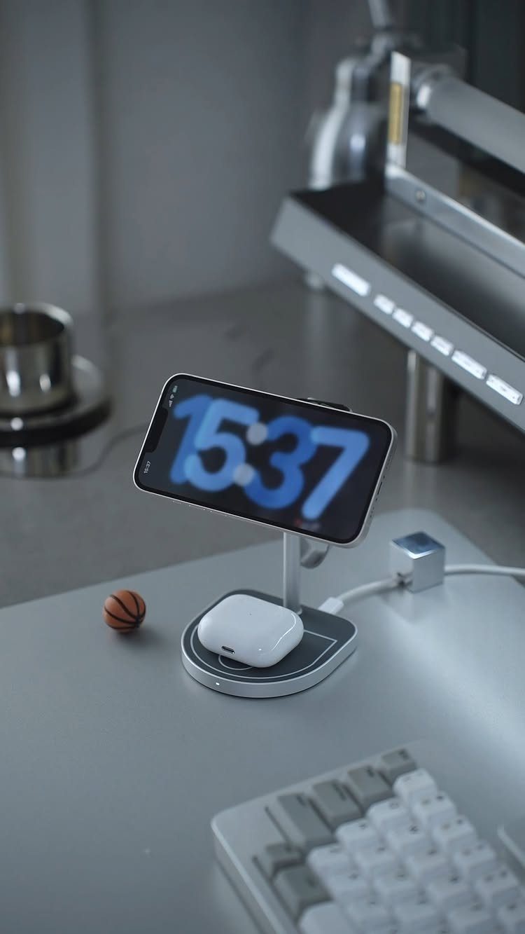 Wireless charging station with smartphone and earbuds on a modern grey desk