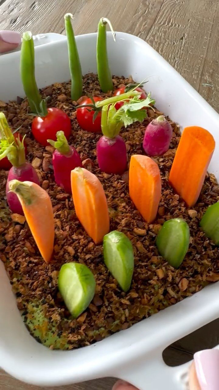 Vegetable garden tray with carrots, radishes, and peas planted in brown crumble.