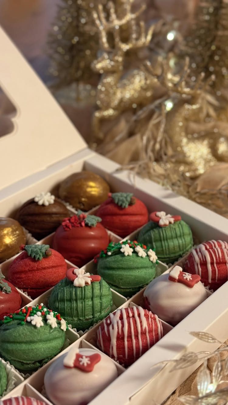 Chocolate covered strawberries in red, green, and white in a white gift box.