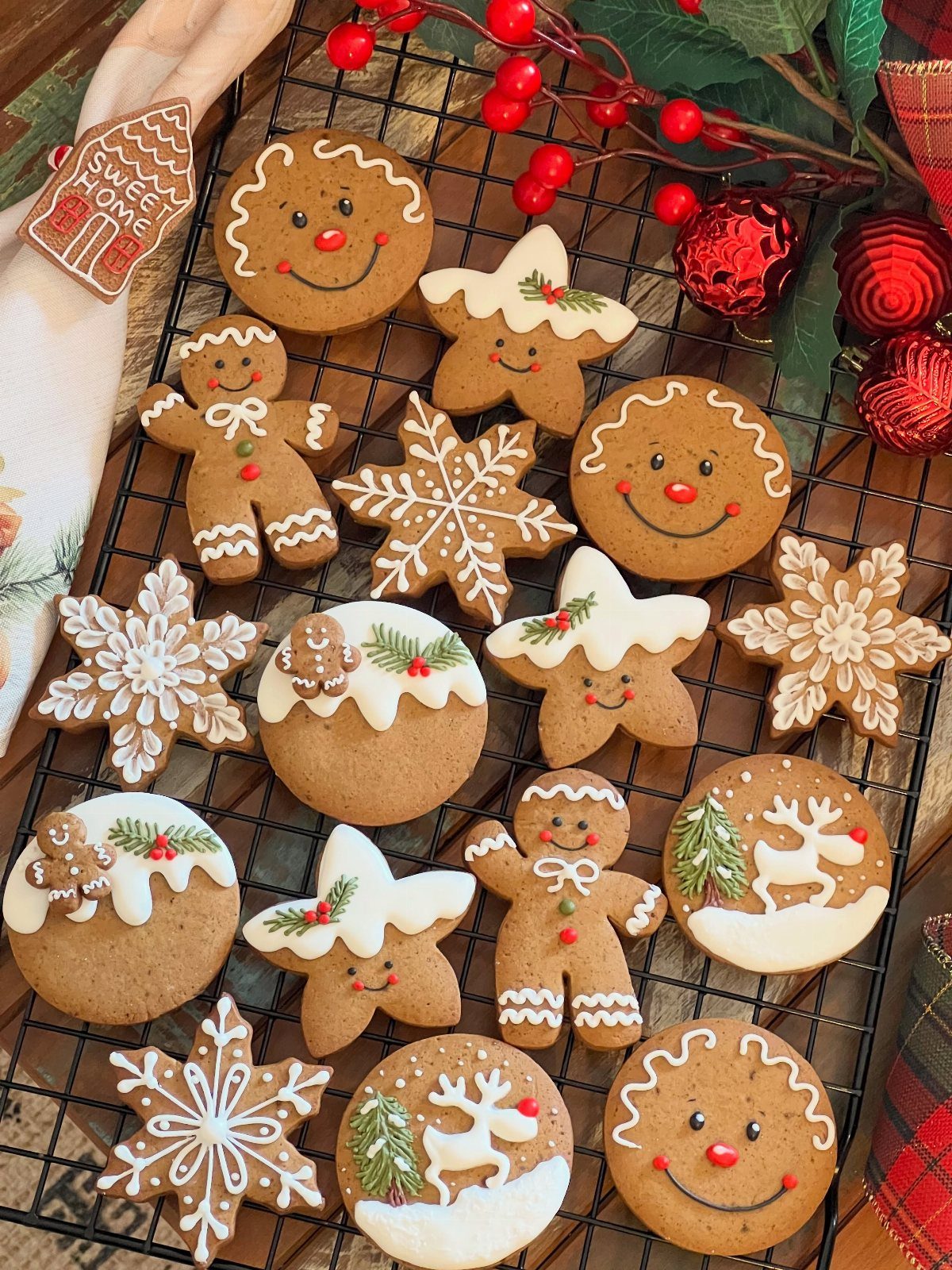 Gingerbread cookies in various shapes with white icing on a wire cooling rack.