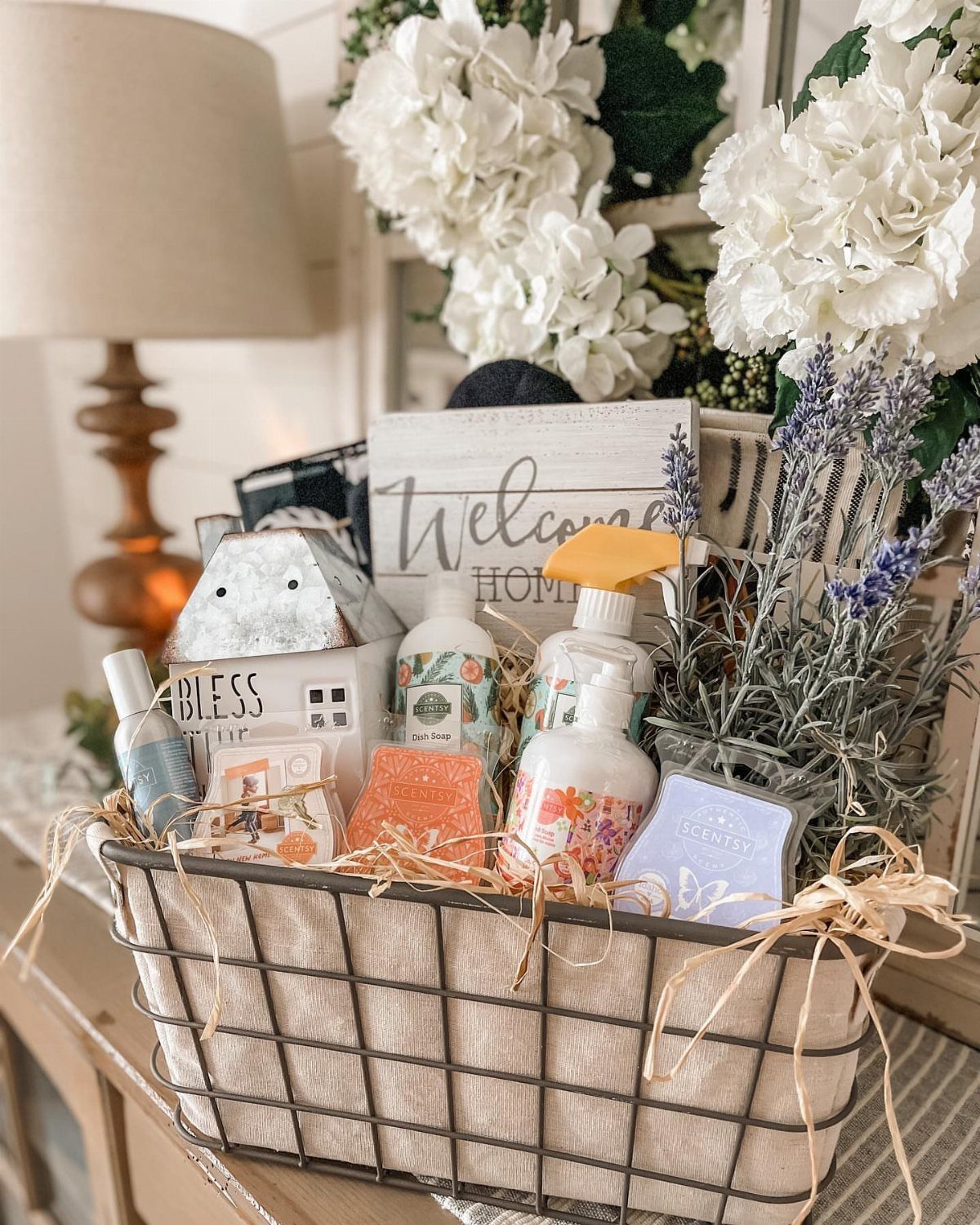 Wire gift basket filled with soaps, lotions, home decor, and dried lavender flowers.