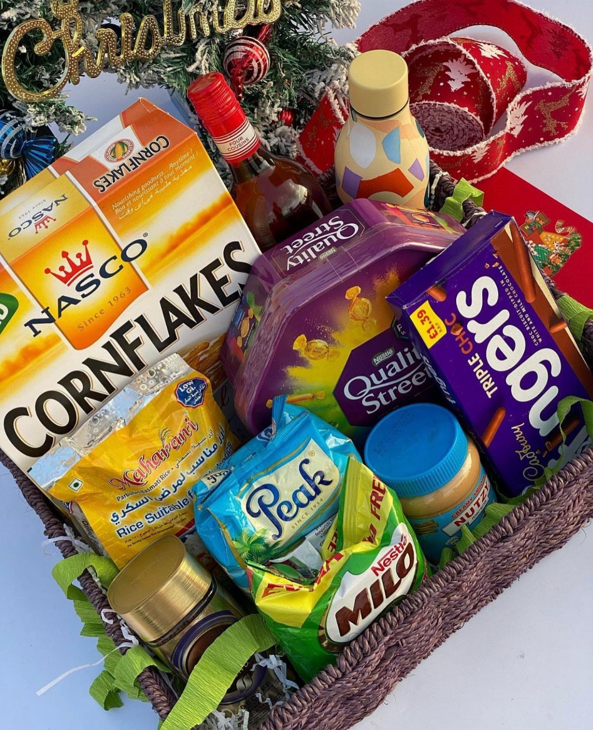 Wicker gift basket filled with assorted snacks and cereals for Christmas celebration