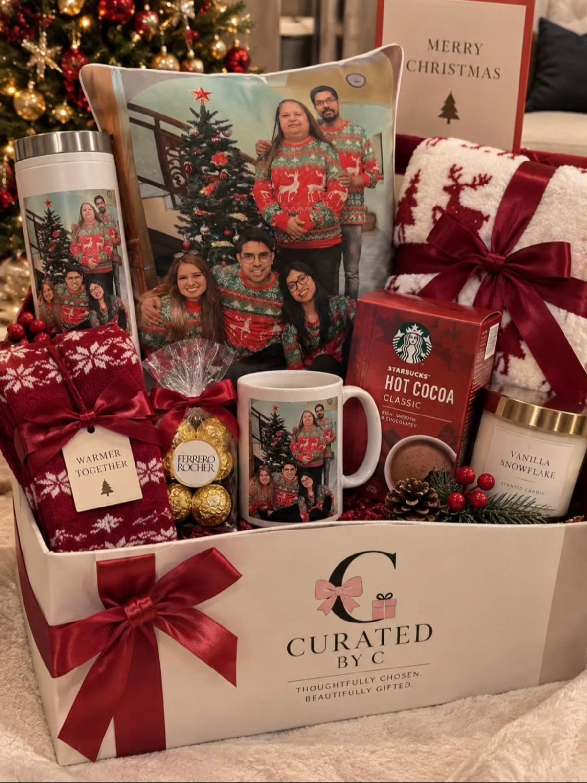 White holiday gift box filled with personalized family photos, cocoa, and cozy blankets.