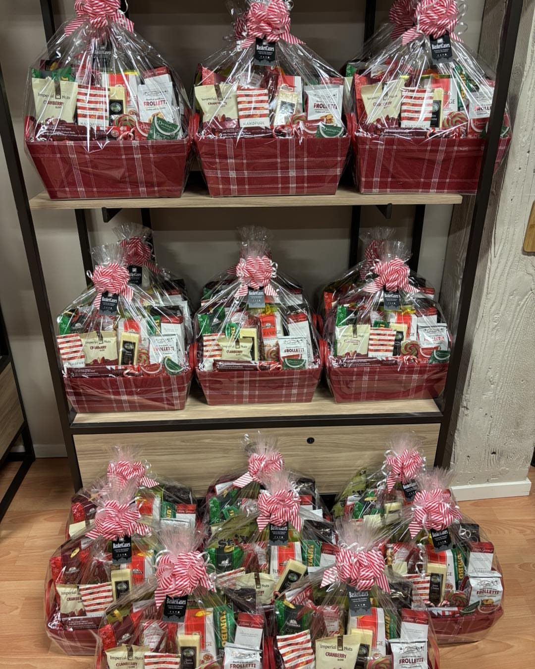Red plaid gift baskets filled with assorted sweets and treats wrapped in cellophane.