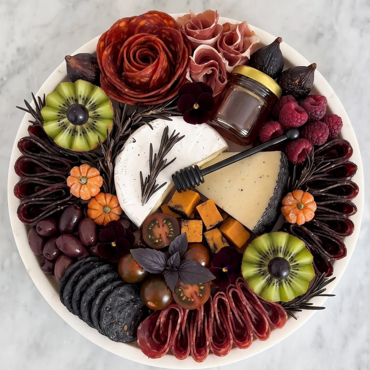 Small orange pumpkins nestled among cheeses, meats, and fruits on a charcuterie platter.