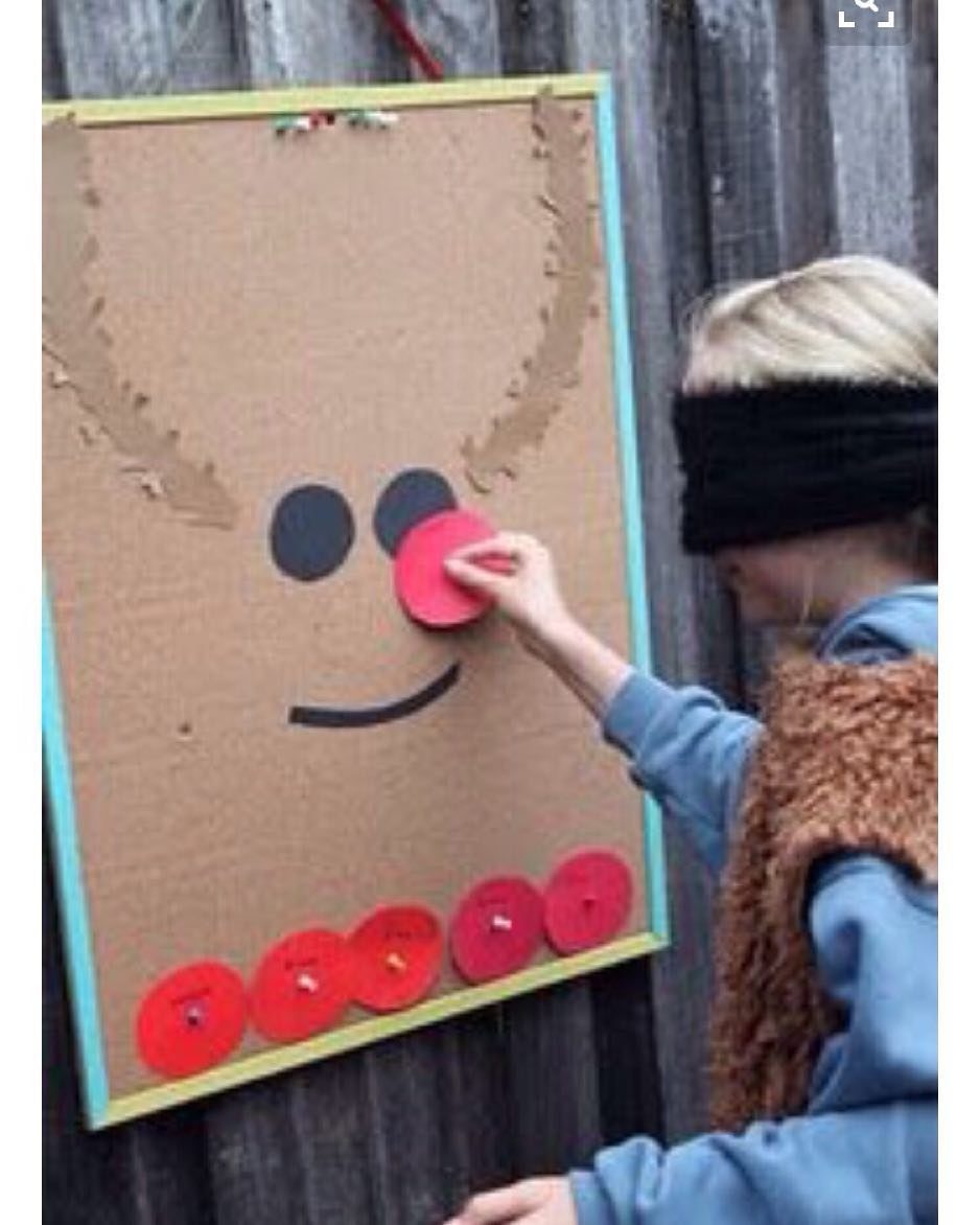 Blindfolded child pinning a red nose on a cardboard reindeer face game