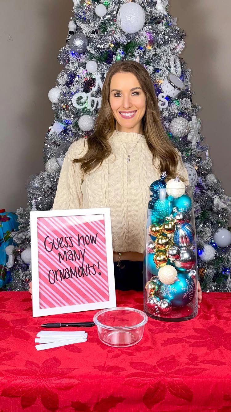 Woman standing behind a jar of Christmas ornaments for a guessing game.