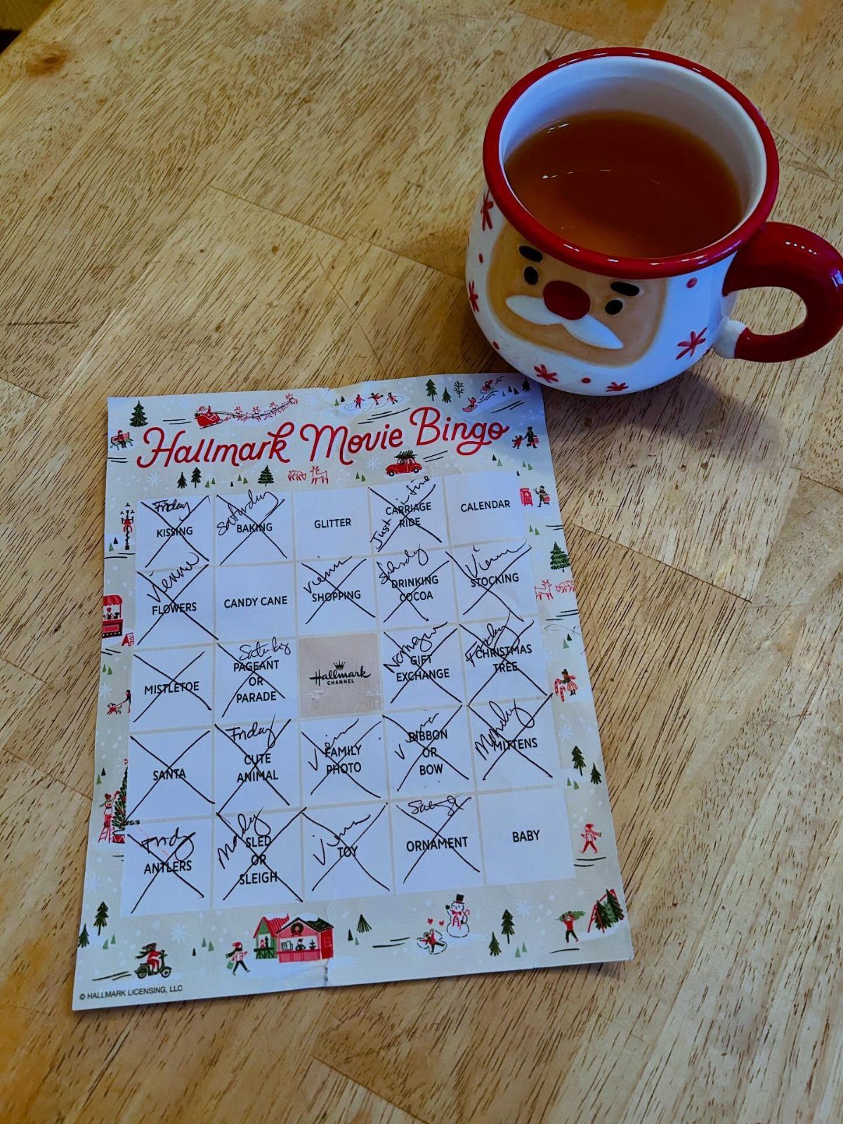 Hallmark Movie Bingo card and a Santa mug on a wooden table