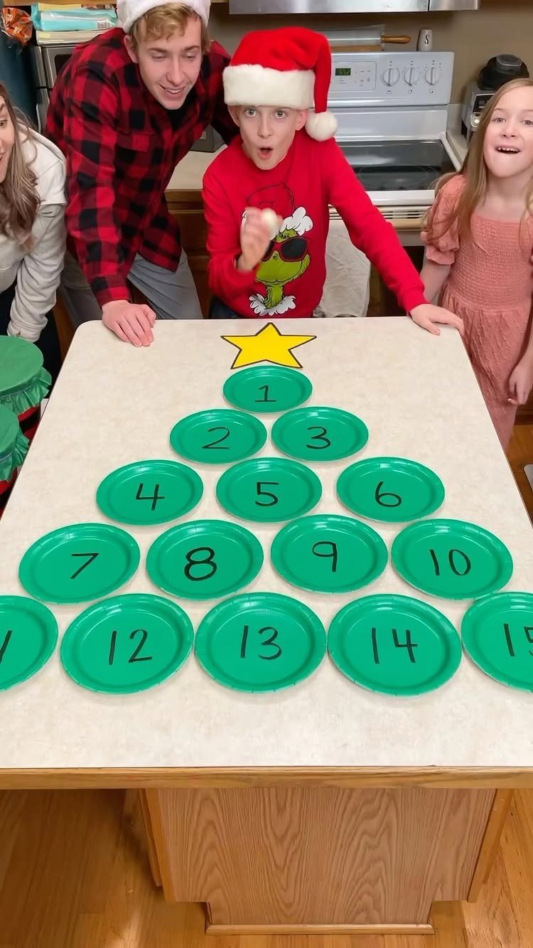 Family standing behind a Christmas tree made of numbered green plates on a table.