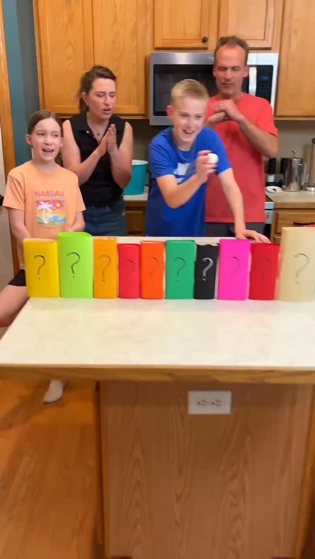 Family playing a game with colorful question mark blocks in a kitchen