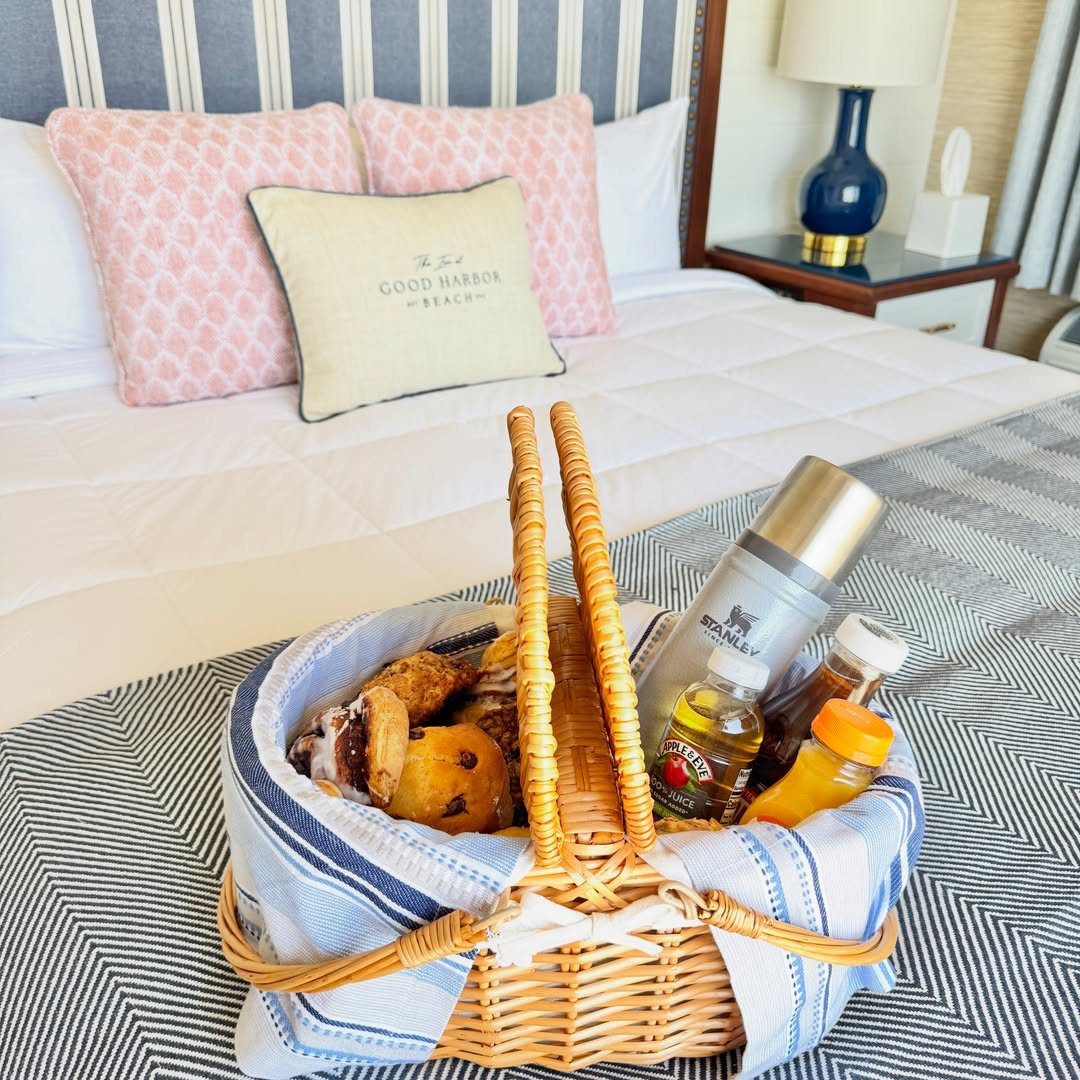 Wicker breakfast basket with pastries and a thermos on a hotel bed