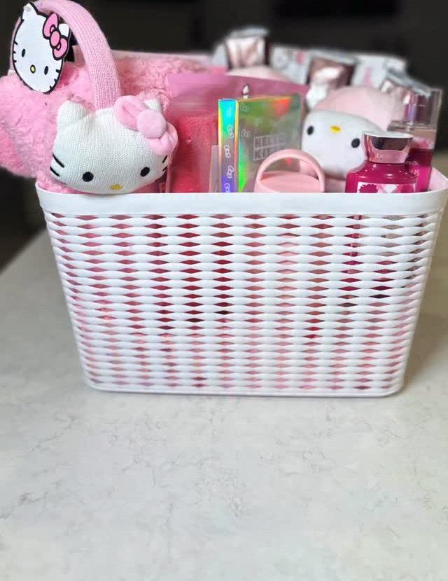 White woven basket filled with pink Hello Kitty themed gifts and accessories.