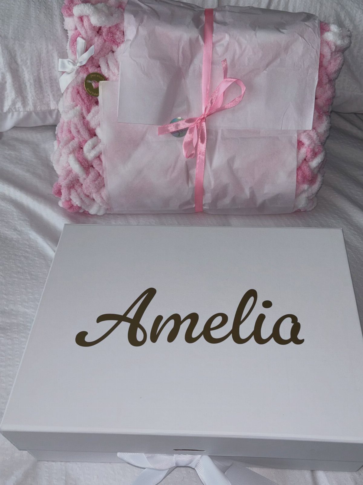 White personalized box with gold name Amelia and a pink knit blanket.