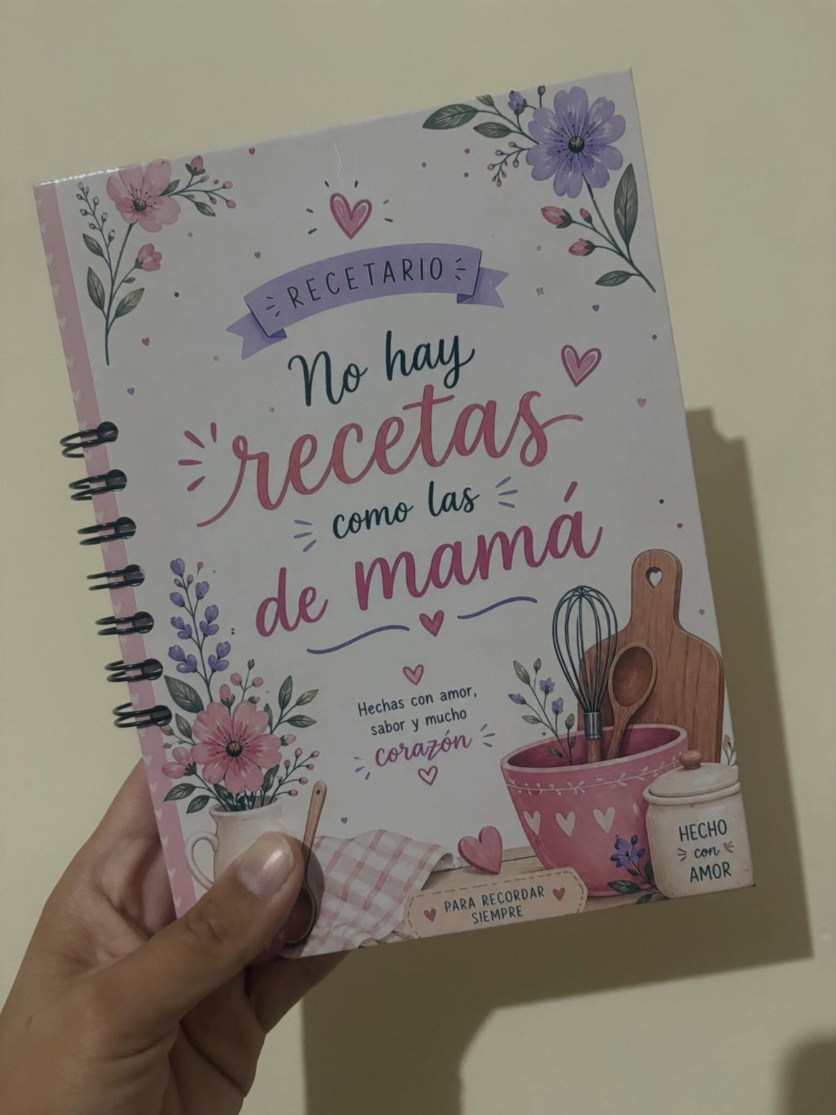 Spiral-bound recipe book with floral cover and Spanish text about mom's recipes.