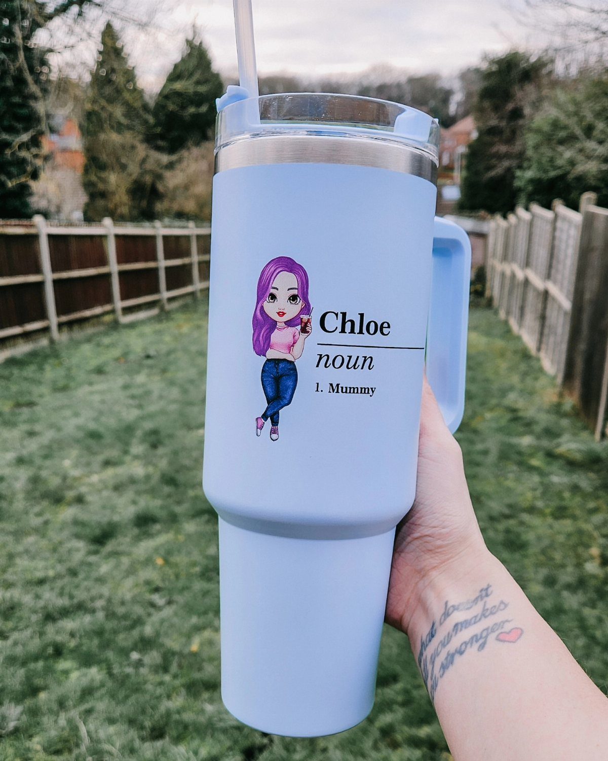 Light blue insulated tumbler with a cartoon girl and 'Mummy' text held outdoors.