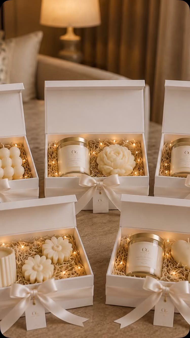 Scented candles and flower-shaped candles in white gift boxes with fairy lights.