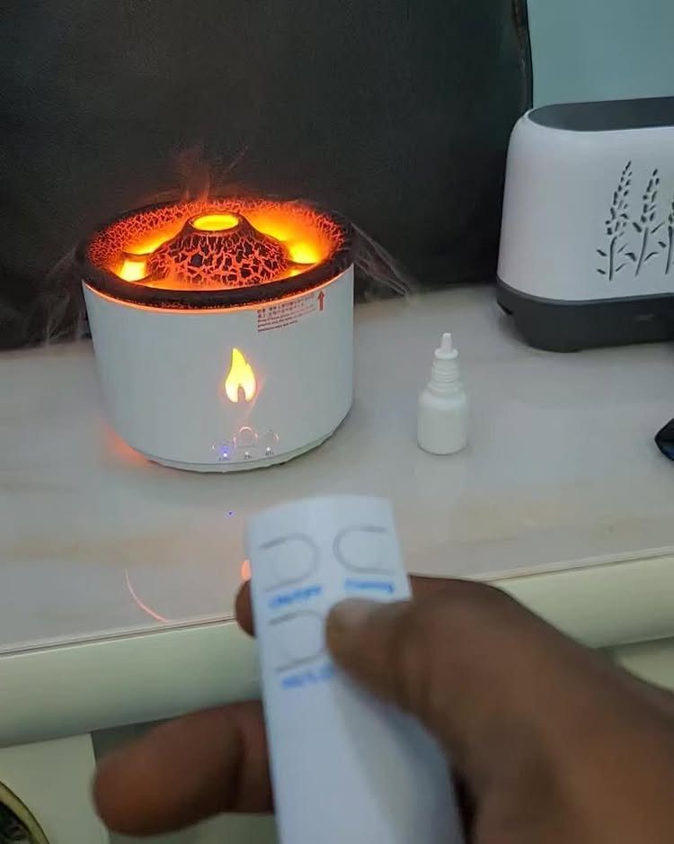 Volcanic aroma diffuser with orange light and mist on a white table