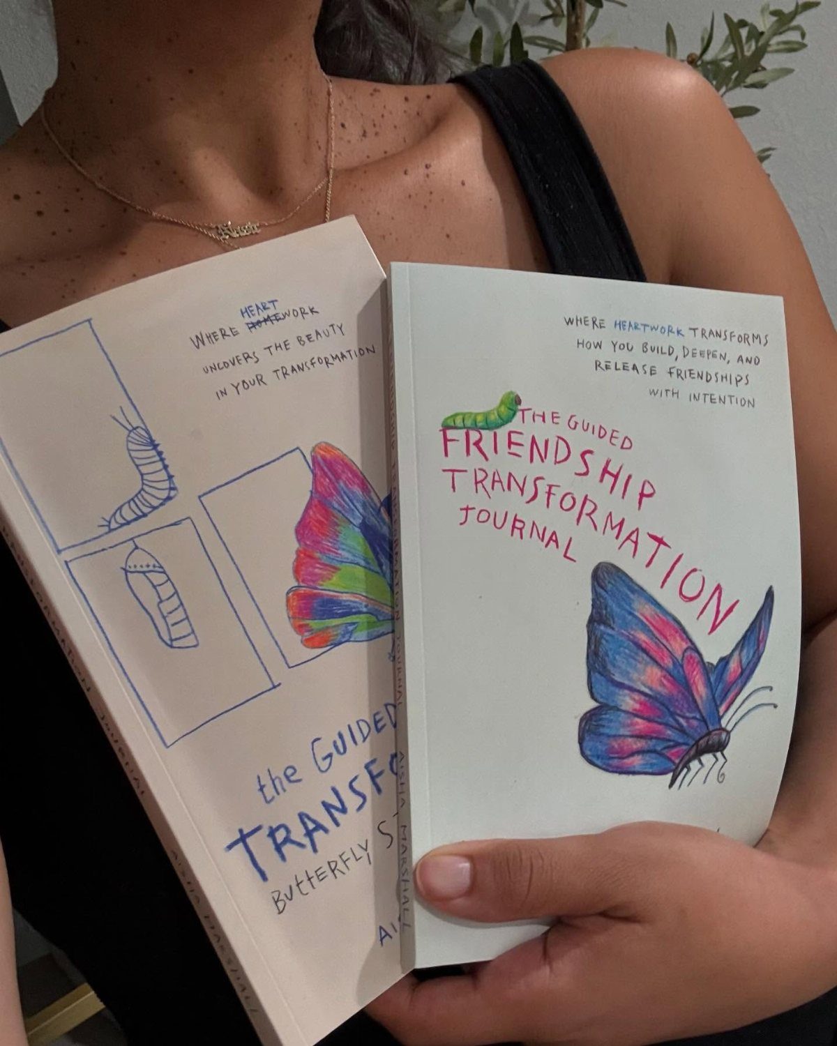 Guided friendship transformation journal with colorful butterfly and caterpillar illustrations held by person