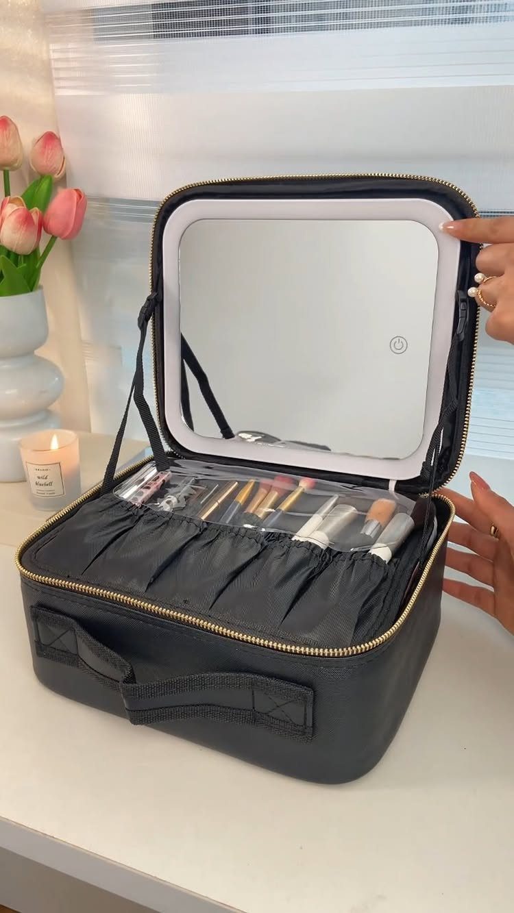 Black makeup organizer case with lighted mirror and brushes on a white table