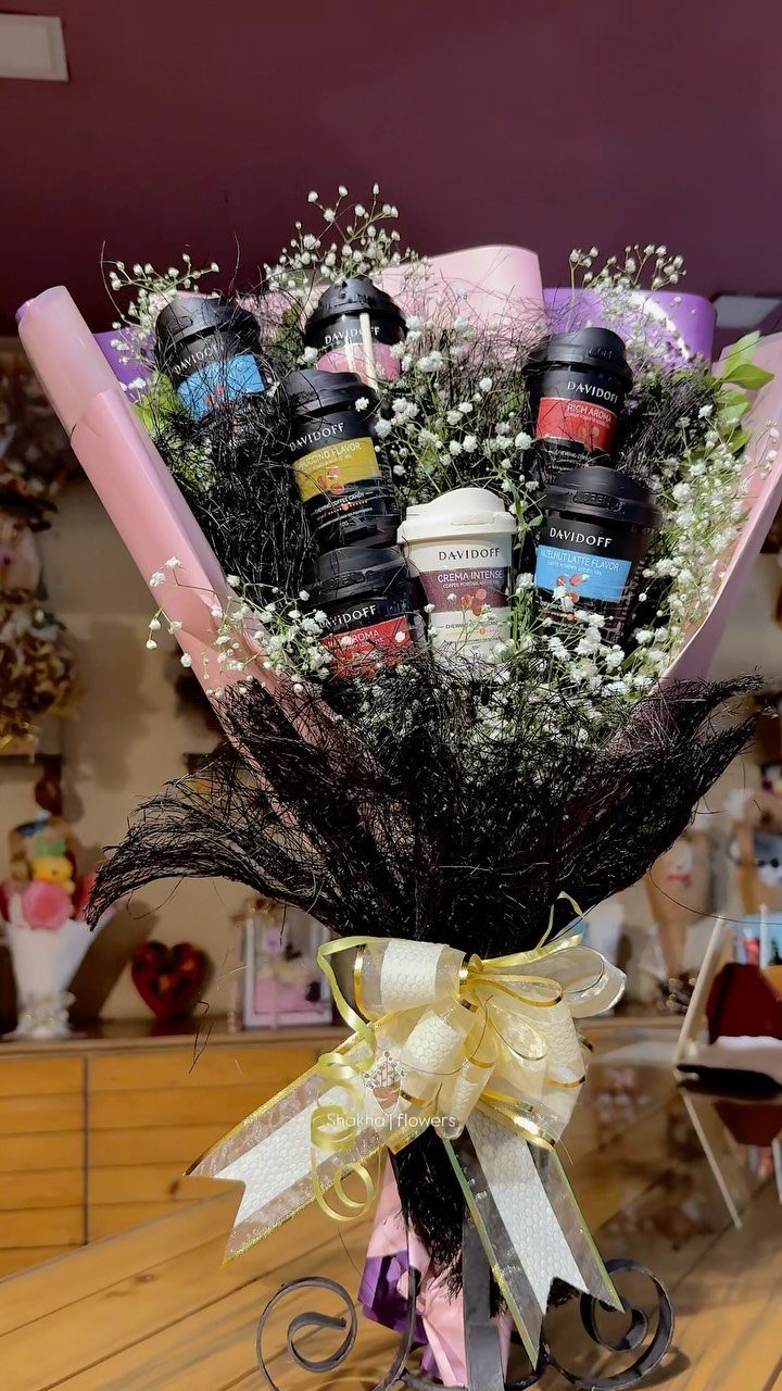 Gift bouquet with small jars of coffee and white baby's breath flowers.