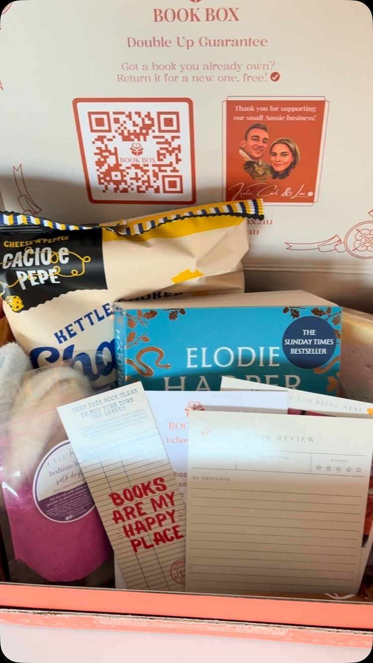 Curated gift box with a blue book, snacks, and themed stationery items.
