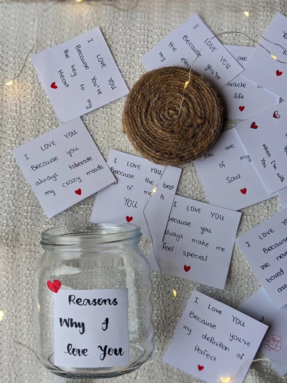 Glass jar labeled Reasons Why I love You surrounded by handwritten love notes.