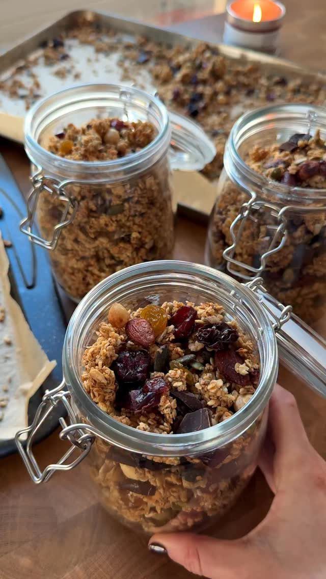 Granola with dried fruit and chocolate chunks in glass clamp-top jars.