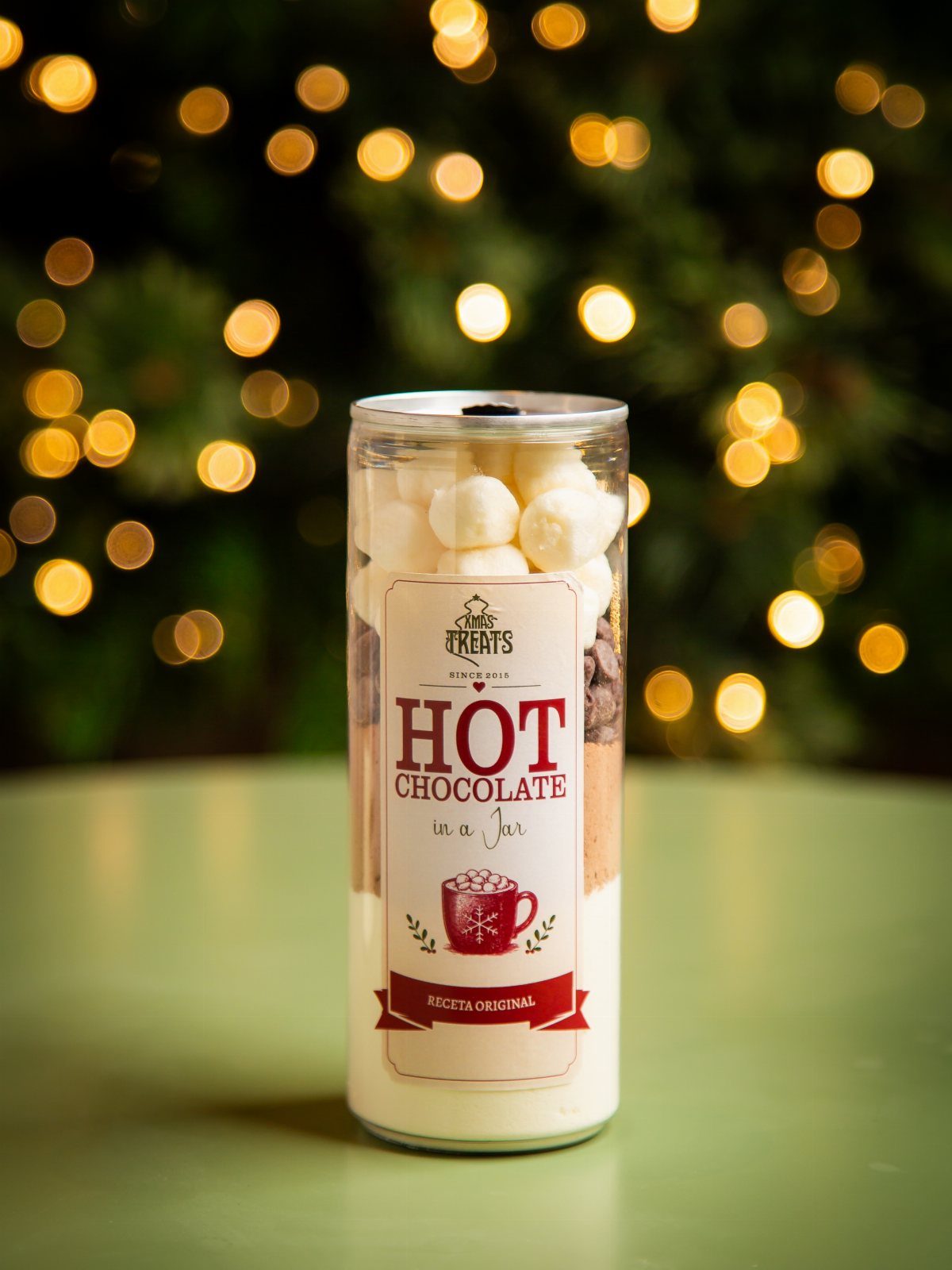 Layered hot chocolate mix in a glass jar topped with white marshmallows.