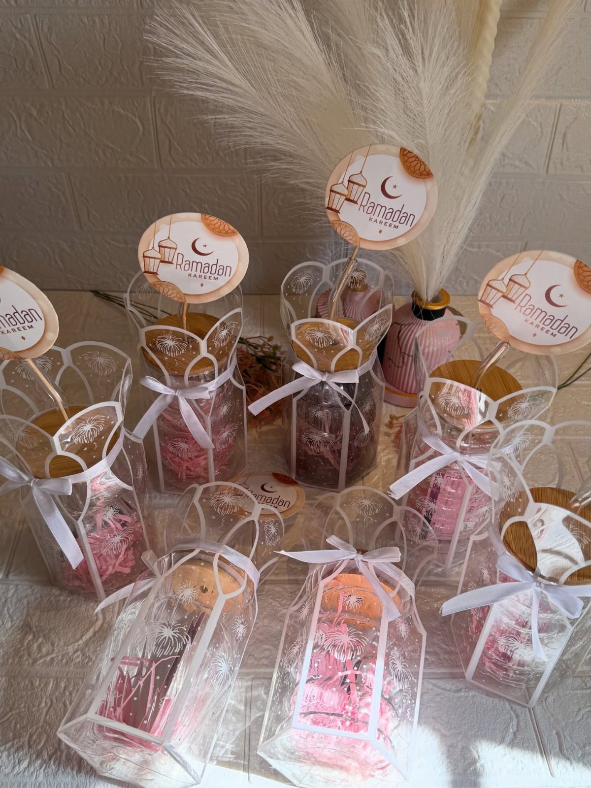 Clear plastic jars filled with treats and pink shredding, tied with white ribbons.