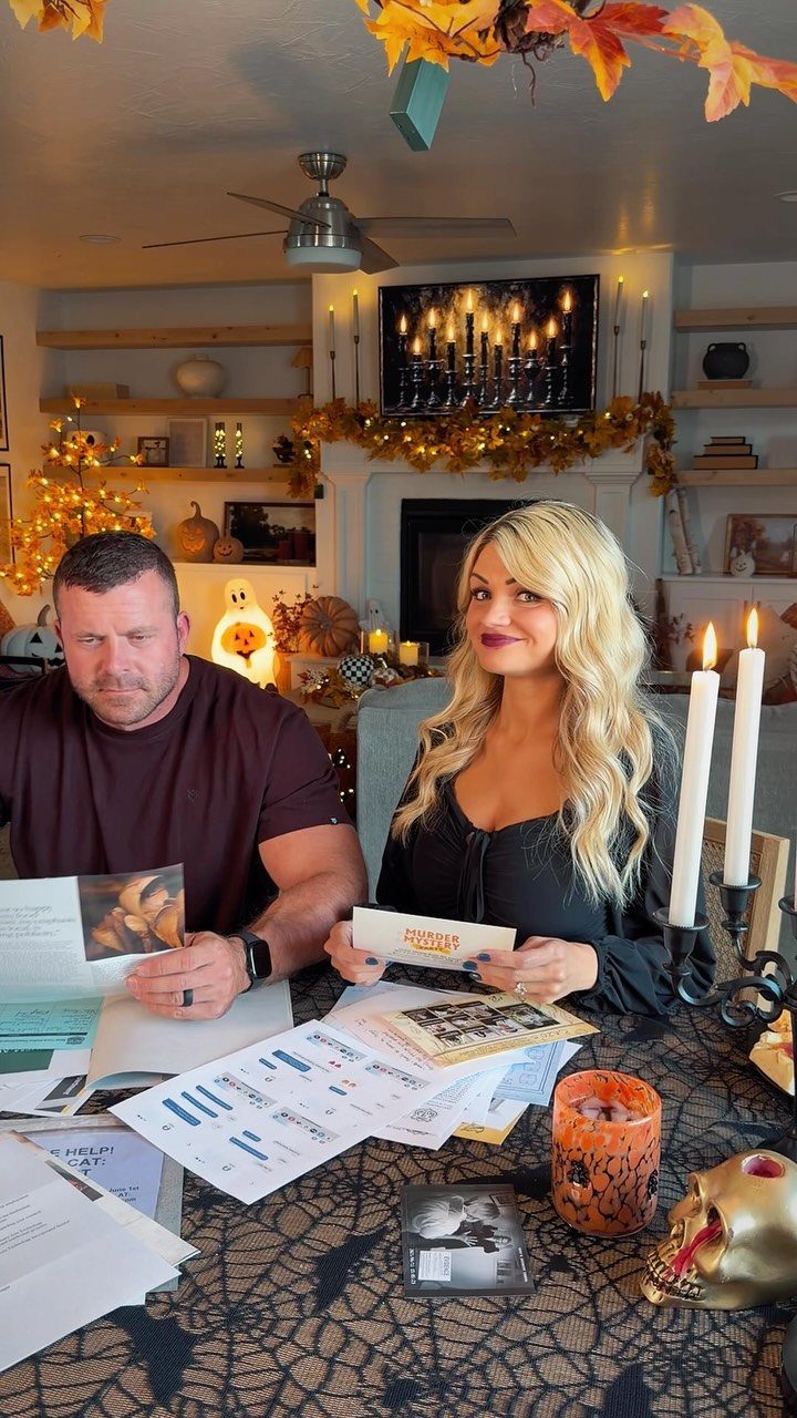 Man and woman playing a murder mystery game at a Halloween decorated table.