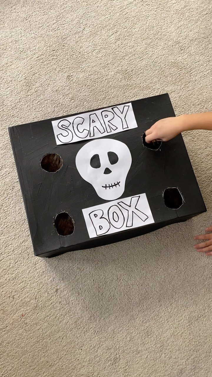 Black scary box with skull and holes for a Halloween sensory game.